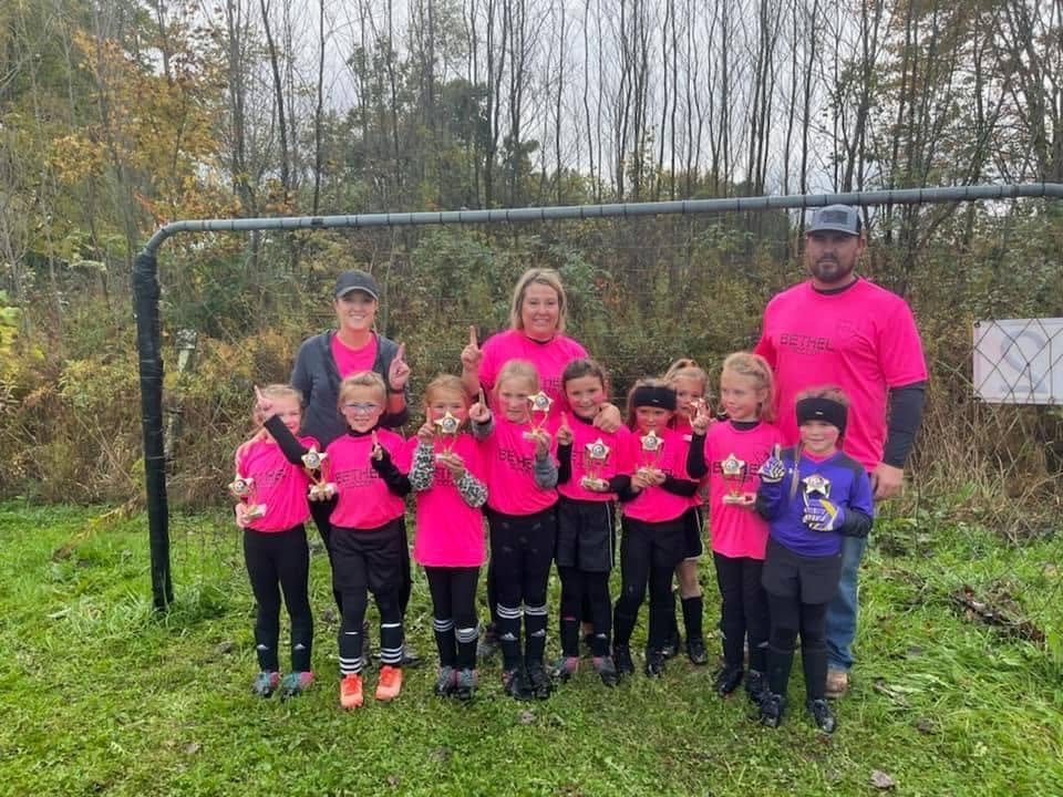 Bethel soccer team in pink with coaches